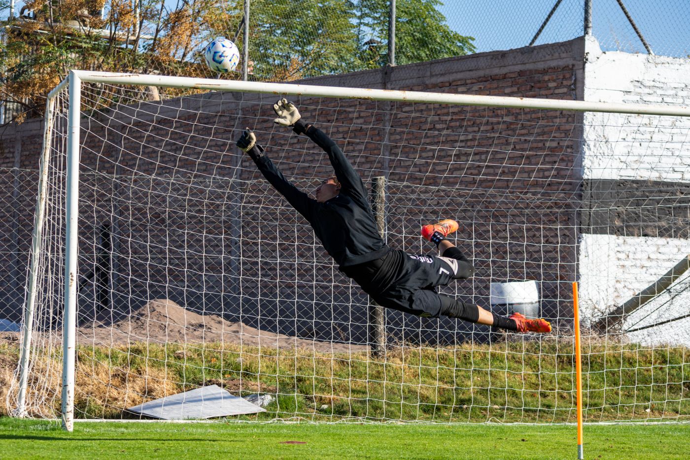 Goalkeeper leaping high to make a save during a match
