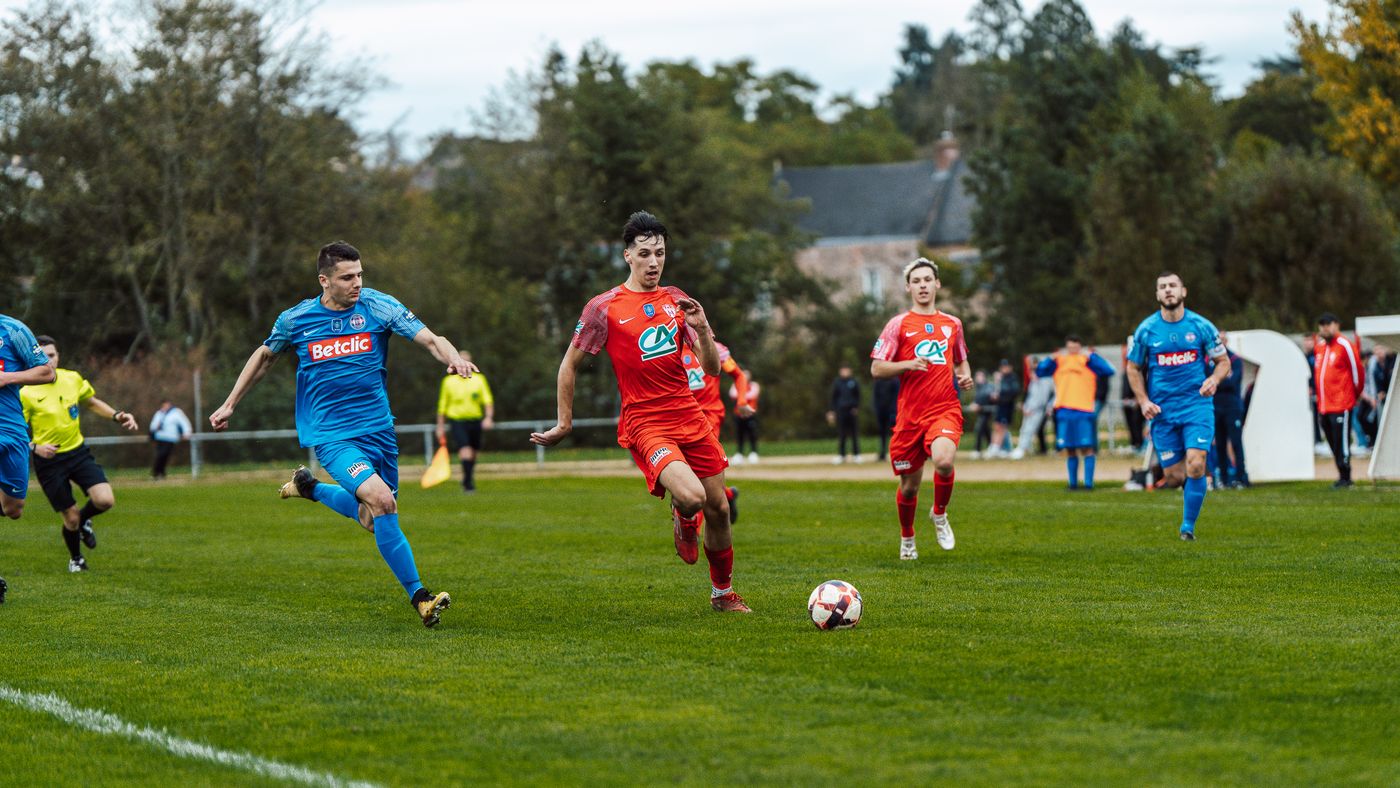 Players in red and blue jerseys contesting a match in France