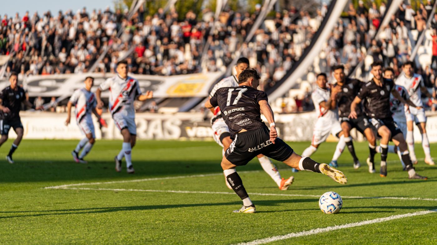 Football match in motion in front of a packed stadium